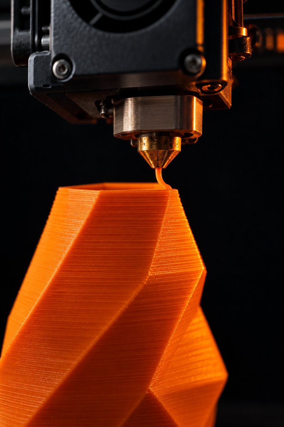 3D printer nozzle extruding orange filament